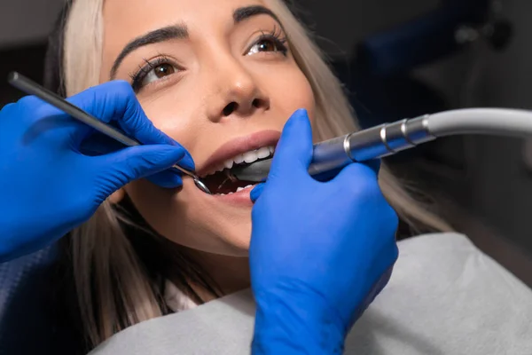 Dentista Perfora Diente Una Paciente Femenina Una Silla Dental Primer —  Fotos de Stock