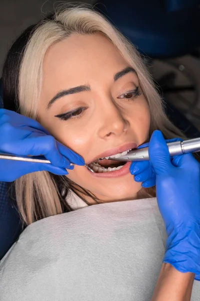 Tandläkare Borrar Tand Till Kvinnlig Patient Tandstol Närbild Tandläkarens Händer — Stockfoto