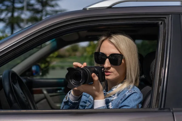 stock image Hidden photographing. Paparazzi Concep Photographer uses his professional camera. Photographer girl in car window. Mobile reporter. Photojournalist at work. Detective or investigator.