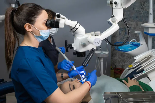 Dwie Dentystki Pracujące Mikroskopem Dentystycznym Doktor Jego Asystent Klinice Dentystycznej — Zdjęcie stockowe