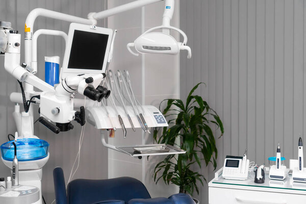 Dentist's office with modern chair and professional equipment. Camera movement around office. Modern interior with display and monitor, instrument and light. Microscope and chair.