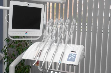 Konsept dişçi odası ofisi. Çeşitli diş aletlerine yakın çekim, ekran, monitör ve mikroskop. Diş hekimliği konsepti. Hastane içi dişçi işyeri - sandalye, ekipman, aletler