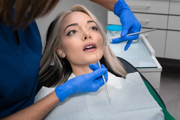 Dentysta Bada Zęby Młodej Pacjentki Nowoczesnym Gabinecie Dentystycznym — Zdjęcie stockowe