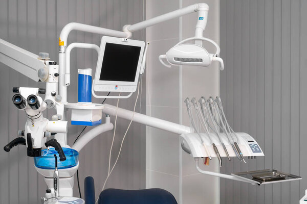 Concept dentists room office. Close-up of various dental instruments, display, monitor and microscope. Dental office concept. Hospital interior with dentist workplace - chair, equipment, instruments