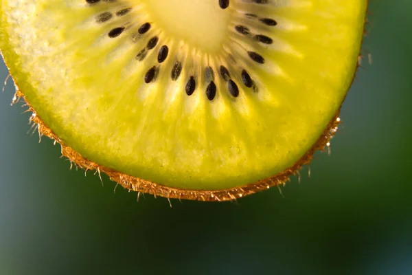 鮮やかな緑色の背景にあるキウイのスライスのクローズアップ マクロ写真 フルーツの背景 — ストック写真