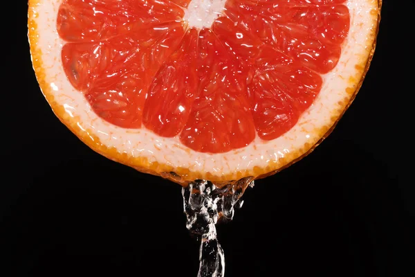 Close Van Een Schijfje Grapefruit Met Waterdruppels Een Zwarte Achtergrond — Stockfoto
