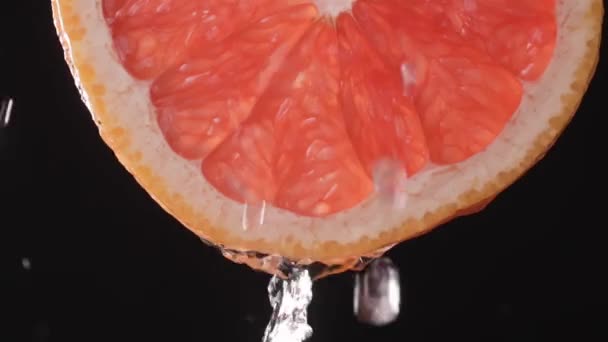 超慢速拍摄的切碎柚子片与水花在空气中的黑色背景 清新爽口的柑橘香味 柠檬水或果汁慢动作 — 图库视频影像