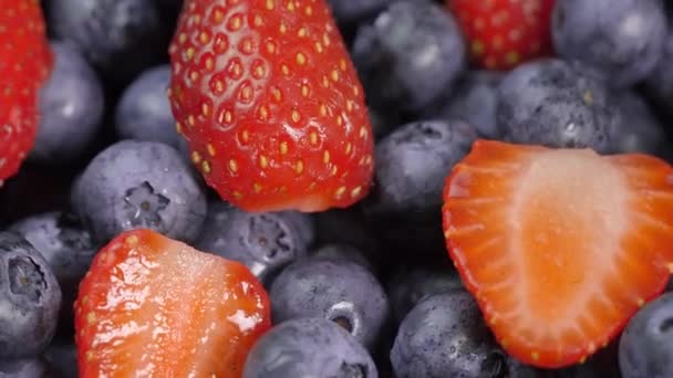 蓝莓和草莓在转盘轴上旋转 森林果实 多汁的浆果顶视图 混合着新鲜的夏天浆果的芬芳 红色和黑色的浆果 健康的生活方式 — 图库视频影像