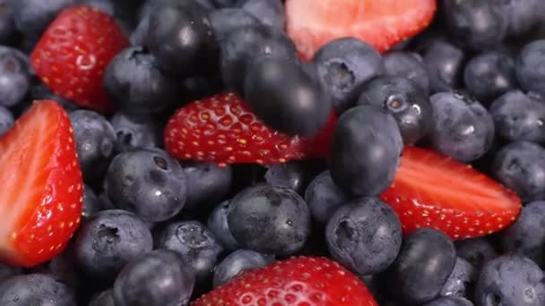 蓝莓和草莓在转盘轴上旋转 森林果实 多汁的浆果顶视图 混合着新鲜的夏天浆果的芬芳 红色和黑色的浆果 健康的生活方式 — 图库视频影像
