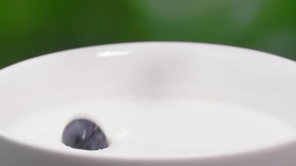イチゴ ラズベリー ブルーベリーのトップビューは汚れたスプラッシュでミルクに落ちます ボウルでミルクに落ちる新鮮な赤いイチゴ ミルクセーキ ヨーグルト スムージーを作る 健康的な食事の概念 — ストック動画
