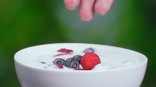 覆盆子 蓝莓掉在牛奶里 溅满了脏水 尽收眼底 新鲜的红草莓掉在碗里的牛奶里 做奶昔 酸奶或冰沙 健康饮食的概念 — 图库视频影像