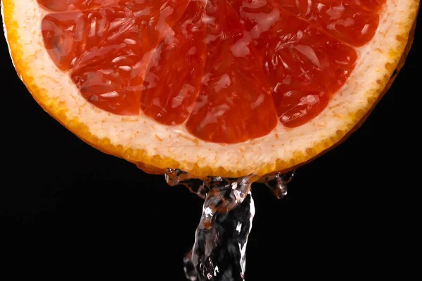 Makro Fotózás Egy Szelet Grapefruit Cseppekkel Fröccsenő Víz Fekete Alapon — Stock Fotó