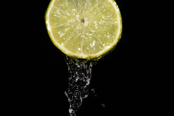 Närbild Saftig Mogen Skiva Lime Med Vackra Stänk Vatten Svart — Stockfoto