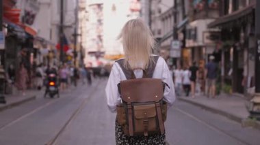 İstanbul 'da Türk caddesinde, üzerinde tramvayların, rayların olduğu yolda yürüyen beyaz tişörtlü, güzel bir kadın kalabalık ve gezgin şehir insanlarına karşı. Istiklai.