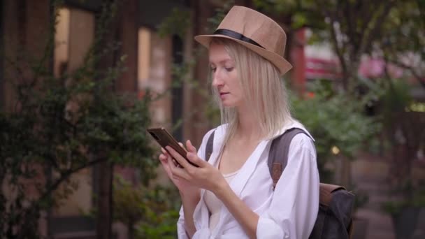 Mulher Turística Com Mochila Usando Chapéu Saloon Usando Smartphone Rua — Vídeo de Stock