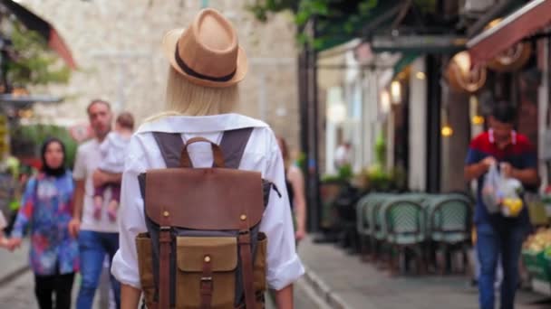 Вид Сзади Блондинки Туристки Белой Рубашке Рюкзаке Сломанной Шляпе Идет — стоковое видео