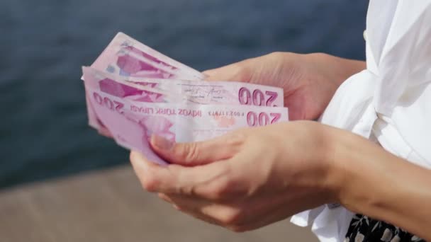 新しいトルコのリラ紙幣を数える手のクローズアップ 手は200リラの顔の価値を持つトルコリラの紙幣を保持し お金を数えています 金融戦略と貯蓄の概念 — ストック動画