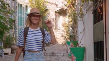 Eski Türkiye ya da Yunanistan caddesinde yürüyen sırt çantalı, güzel, beyaz tenli kadın turistin portresi. Seyahat tutkusu konsepti atmosferik destansı güzel an.