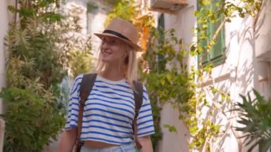 Eski Türkiye ya da Yunanistan caddesinde yürüyen sırt çantalı, güzel, beyaz tenli kadın turistin portresi. Seyahat tutkusu konsepti atmosferik destansı güzel an.