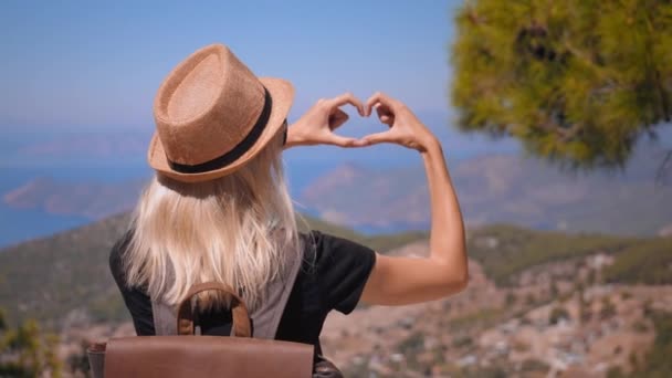 Sırt Çantalı Şapkalı Kadın Gezgin Kalp Şeklinde Semboller Yaparak Dağları — Stok video