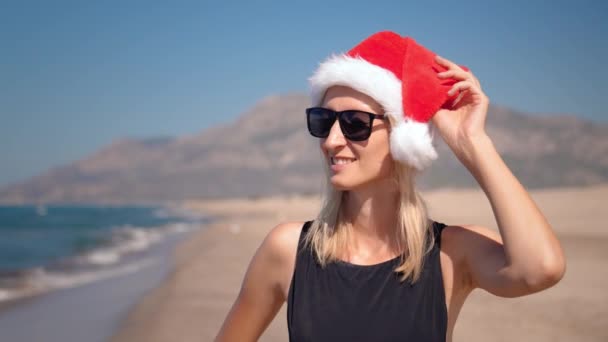 Noel Noel Baba Şapkası Takan Genç Bir Kadın Plajda Deniz — Stok video