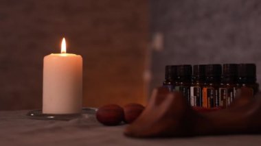 Salondaki doğal yağlı spa tedavisi konsepti. Rahatlama atmosferi, disiplin. Aromaterapi, mum ateşi, havlu, ahşap arka plan ve yağ şişeleri. Cilt Bakımı, Cilt Bakımı