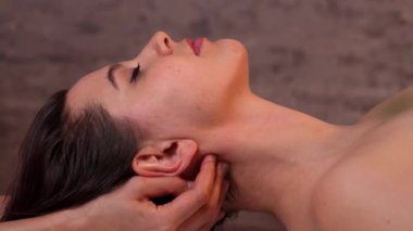 Spa 'da boyun omuz masajı. Kapalı ruhban sınıfı ve makyajlı beyaz bir kadın masaj yaptırıyor. Rahatlatıcı terapi görüyor. Çıplak bir müşteri, mükemmel bir cilt masajı. Sağlıklı yaşam tarzı kavramı