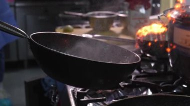 Şefin elleri yiyeceği halıya atar, alevlere dönüşür ve yavaş çekimde ateşten tutuşur. Şefin ellerinin ateş içinde yemek pişirdiği yakın plan. Şef profesyonel mutfakta..
