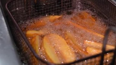 Profesyonel aşçı restoranda tavada kızarmış patatese tuz ekliyor. Yemek pişirme süreci. Restoran menüsü veya yemek tarifi için yer. ertelenmiş hareket.