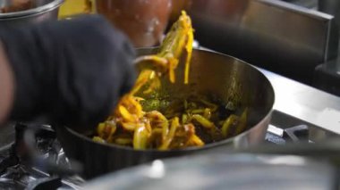 Lokanta mutfağında ya da yemek servisinde tavada kızartılmış, soğanlı, altın hamurlu et ile karıştırılan şefin yakın çekimi. Çatallı Eller Yemek Lezzetli Ev Yemeği