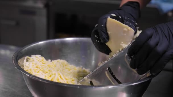 Close Mãos Chef Luvas Pretas Ralando Queijo Ralador Grosseiro Cozinha — Vídeo de Stock