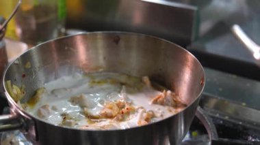 Mutfakta tavada dilimlenmiş mantarlı el yapımı sos ve beşamel soslu kızarmış mantar. Şefin eli süt ekliyor.