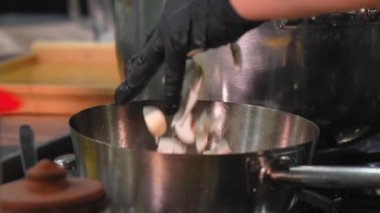 Lokantanın profesyonel mutfağında, şefin elleri gaz sobasında kızartmak için taze mantar, lezzetli yemek pişirmek, kapalı alanda beyaz ışık mutfağı...