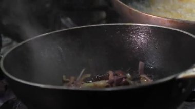 Şefin ellerinin yakın çekimi. Yemeği sebze ve soğan şeklinde hazırlıyor. Şef profesyonel mutfakta yemek yakıyor, etrafa saçıp duruyor. Restoran mutfağı. .