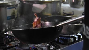 Şefin ellerinin yakın çekimi. Yemeği sebze ve soğan şeklinde hazırlıyor. Şef profesyonel mutfakta yemek yakıyor, etrafa saçıp duruyor. Restoran mutfağı. .