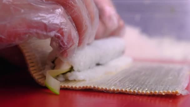 Chef Prepara Sushi Con Pescado Rojo Pepinos Nori Pizarra Roja — Vídeo de stock