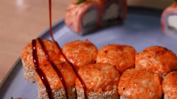 Zbliżenie Szefa Kuchni Wylewając Sos Teriyaki Pieczone Bułki Sushi Talerzu — Wideo stockowe