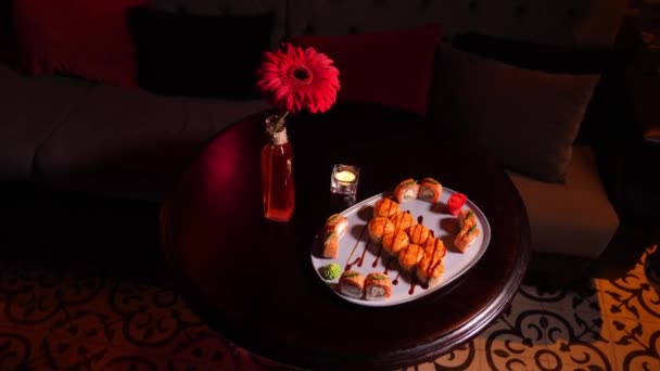 亚洲餐馆的餐桌上摆满了烤好的寿司卷 气氛优美 花朵绽放 点着蜡烛 里面点着淡淡的蜡烛 — 图库视频影像