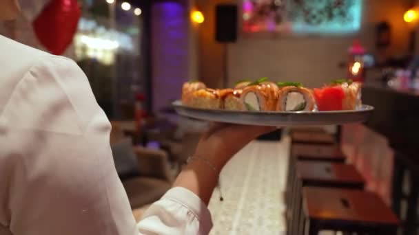 Kamera Följer Kvinnlig Servitör Som Hon Bär Bricka Med Sushi — Stockvideo