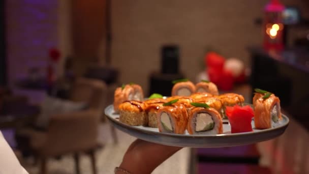 相机跟随女服务员 当她带着一盘寿司或在酒吧或餐馆点菜时 餐厅和酒店业务 配备服务人员 订单交付 — 图库视频影像