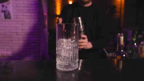 バーテンダーのクローズアップ 混合ストロベリーカクテル シェーカーからガラスにバーカウンターの氷 — ストック動画