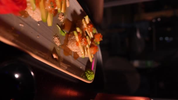 一套美味的 令人垂涎欲滴的寿司 搭配着鸡尾酒 筷子和一只花瓶 晚上在餐厅里开著一朵花 成为大家关注的焦点 垂直视频 — 图库视频影像