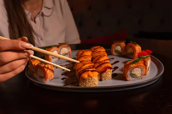 Young Woman Eats Enjoys Fresh Sushi Luxurious Restaurant Girl Holds Stockfoto