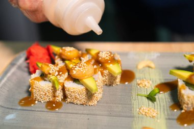 Lokantanın mutfağında şefin nefis ekmekleri susam sosuyla süslüyor, yakın plan. Yiyecek kavramı