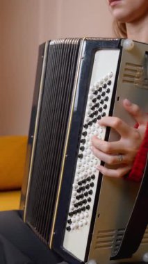 Geleneksel akordeon çalmada usta müzisyenlerin ellerini gösteren yakın plan çekimde, parmaklarının ve enstrümanın karmaşık hareketlerinin vurgulanması. Dikey video