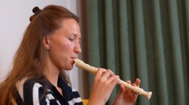 Müzisyenlerin ellerinin flüt çalarken yakın plan çekimleri, müzik notaları üretmek için gerekli parmak hareketleri ve koordinasyonu gösteriyor. dikey video