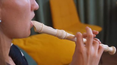 Müzisyen ellerinin yakın plan flüt çalması, titiz parmak hareketleri ve müzik notaları üretmek için gerekli koordinasyonu sergilemesi..