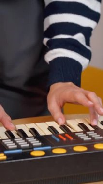 Kadın müzisyen, karmaşık parmak yerleştirmeleri ve antik elektronik sentezleyici enstrümanlarının tuşlarında hassas el hareketleri kaydederek klavye çalma pratiği yapıyor. dikey video