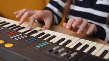 Renkli tuşlara sahip klasik klavyeyi keşfeden kadın eller, yaratıcı performans sırasında karmaşık parmak hareketleri ve çeşitli müzik sekanslarını ortaya çıkarıyor