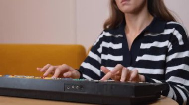 Elektronik klavye sentezleyicisi çalan bayan müzisyen sıcak, rahat oturma odasında nostaljik bir müzik atmosferi yaratarak melodik kompozisyon yoluyla yaratıcı tutkularını ifade ediyor..